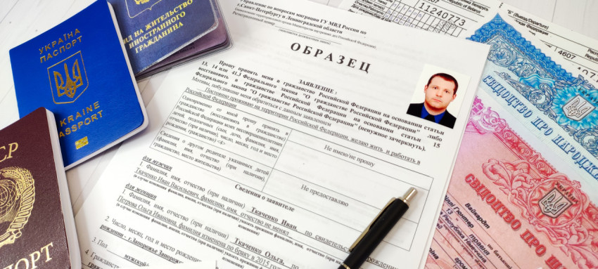 Бланк заявления на гражданство с паспортами и ручкой