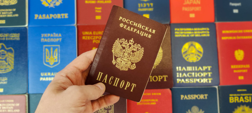 Рука держит паспорт России среди зарубежных паспортов