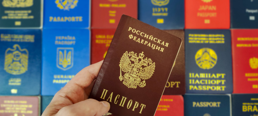 Паспорт России в руке на фоне международных паспортов