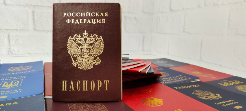 Паспорт Российской Федерации на фоне белой стены и других паспортов