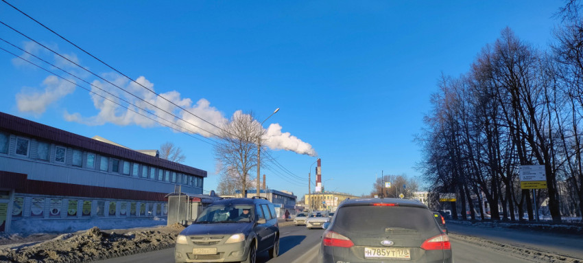 Промышленные здания с дымящимися трубами в городе под голубым небом