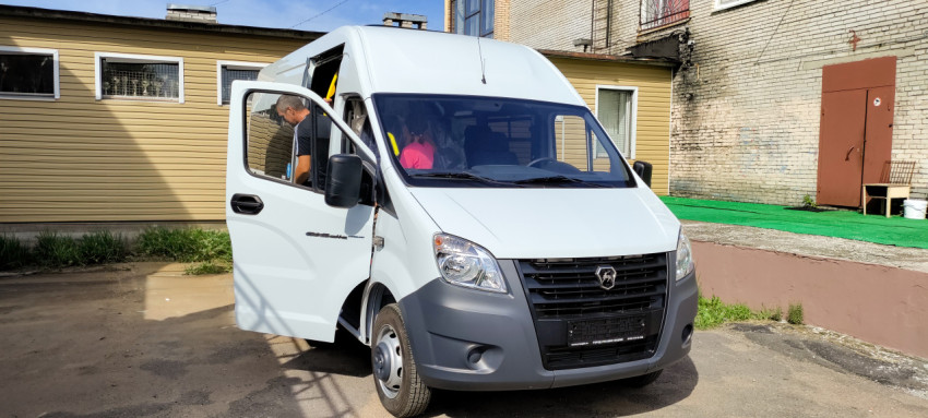 Миниавтобус Газель Next на фоне административного здания