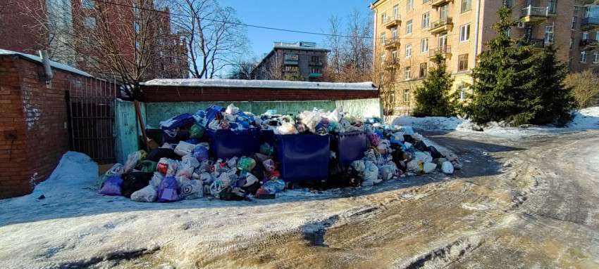 Переполненные контейнеры для мусора во дворе жилого дома