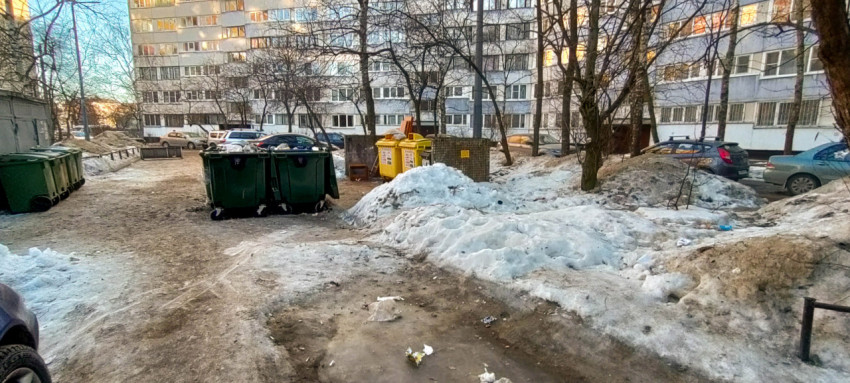 Контейнеры для мусора во дворе многоквартирного дома зимой