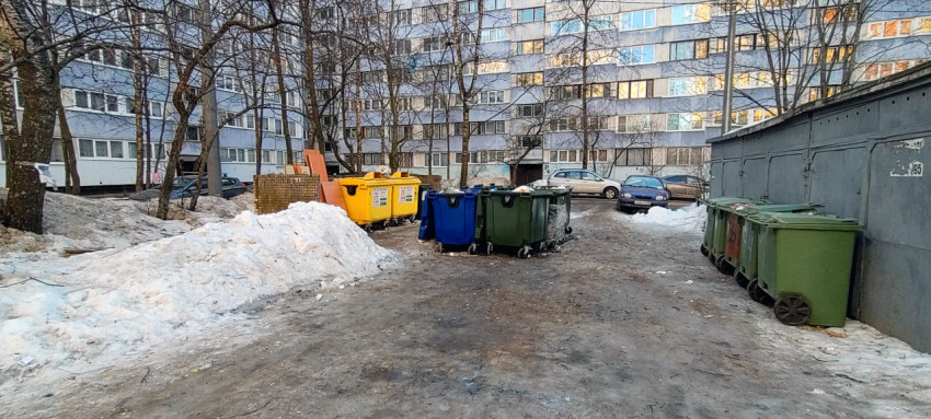 Контейнеры для мусора во дворе многоквартирного дома зимой