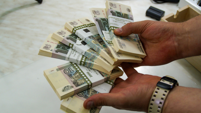 Пачки десятирублевых банкнот в руках