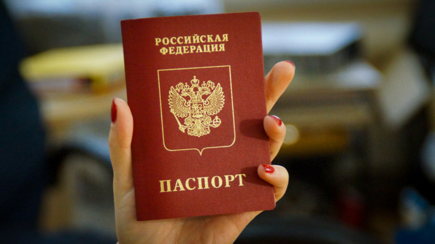 Девушка держит в руке российский загранпаспорт