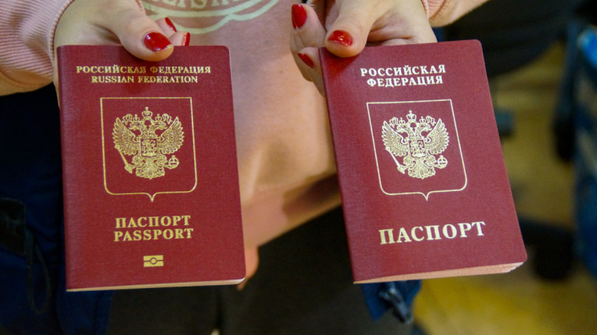 Девушка держит в руках 2 загранпаспорта