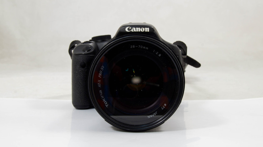 Камера Canon 500D с объективом, снятая на светлом фон