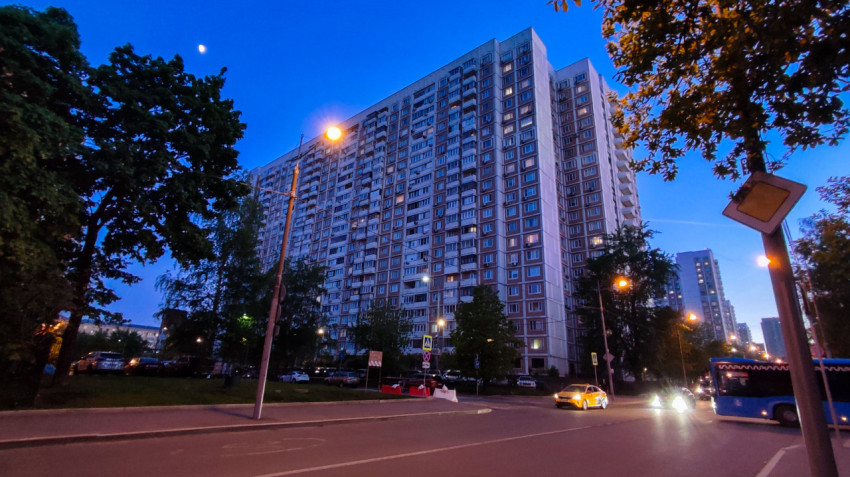 Многоэтажный жилой дом на улице города в вечернее время