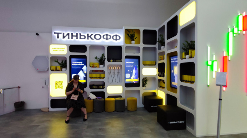 Стенд Тинькофф с интерактивными экранами и зоной отдыха
