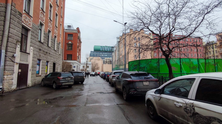 Парковка у зелёного ограждения спортивной площадки