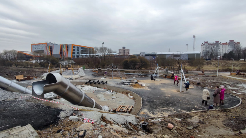 Строящаяся детская площадка с металлическими горками и качелями