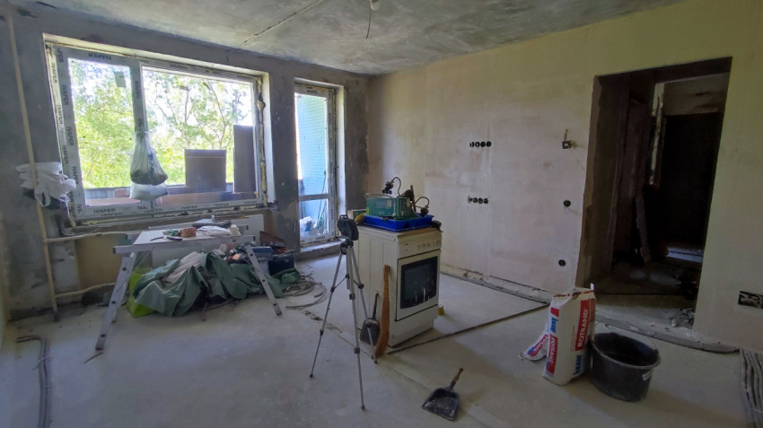 Помещение с окнами и строительным оборудованием в ходе ремонта