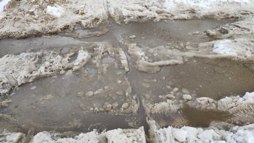 Лужа из талой воды на дороге