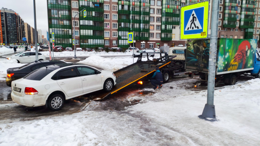Эвакуатор загружает автомобиль на проезжей части