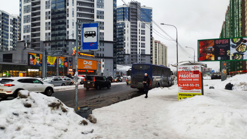 Остановка общественного транспорта на улице в зимний день с автобусом и автомобилями рядом
