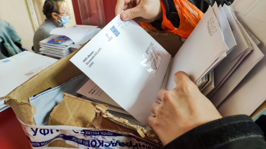 Посетитель почтового офиса ищет свое письмо среди множества конвертов