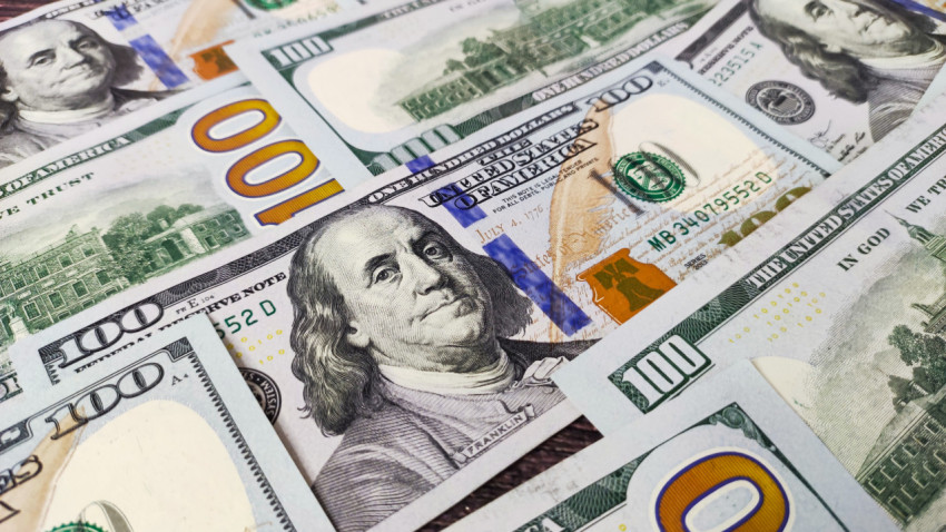Банкноты 100 долларов США, аккуратно уложенные на столе