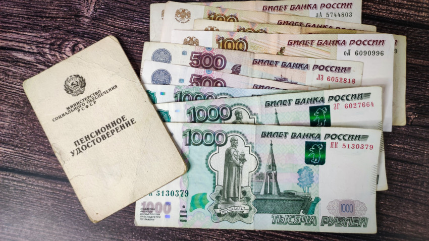 Пенсионное удостоверение и российские рубли на столе