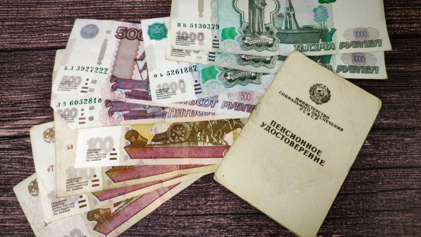Пенсионное удостоверение и деньги на столе
