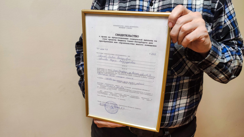 Свидетельство на покупку квартиры в Санкт-Петербурге в руках мужчины