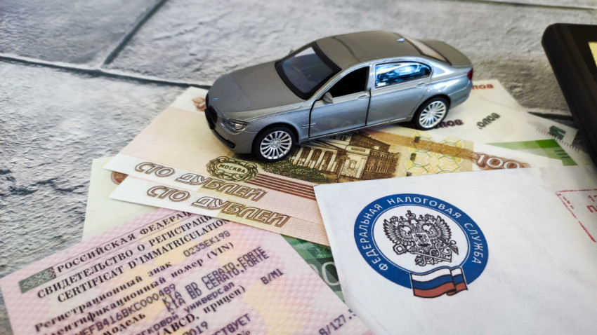 Миниатюрная модель автомобиля и документы на фоне денежных купюр