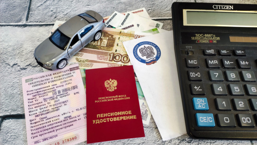 Модель автомобиля на столе с документами и калькулятором