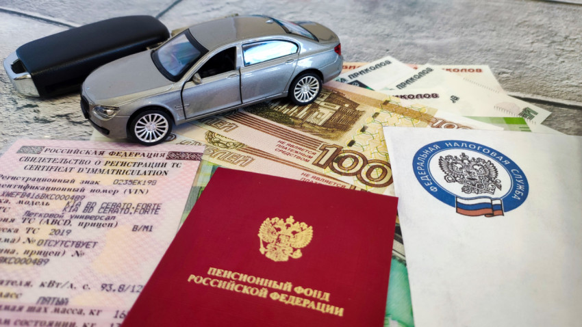Модель автомобиля, ключи, деньги и документы на столе