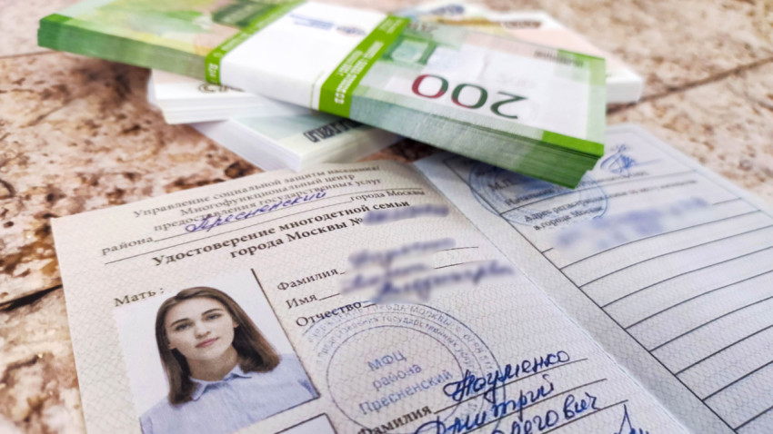 Пачки денег и удостоверение многодетной семьи