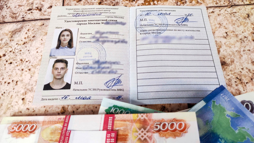 Денежные пачки и удостоверение многодетной семьи