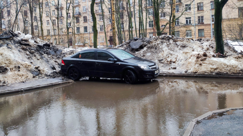 Автомобиль припаркован в луже от тающего снега