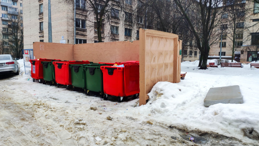 Контейнеры для мусора в снегу возле жилых домов