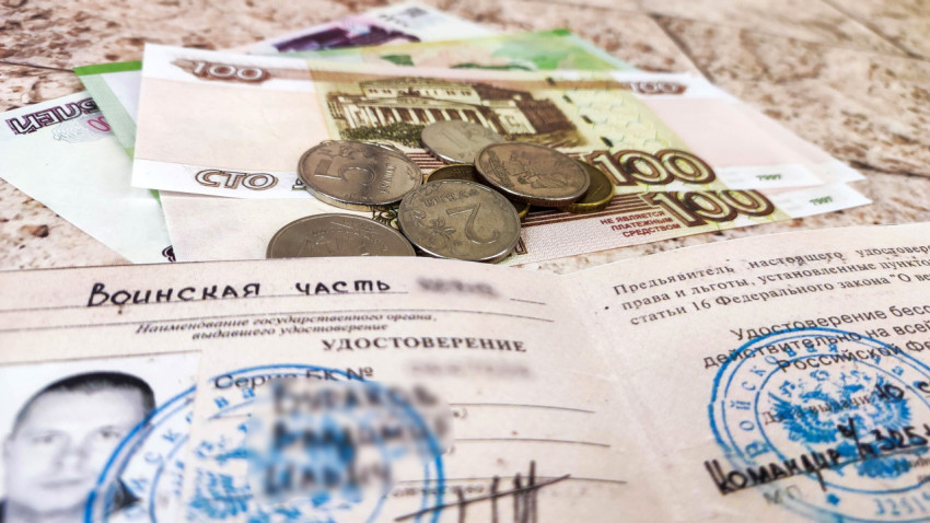 Удостоверение ветерана боевых действий и деньги на столе