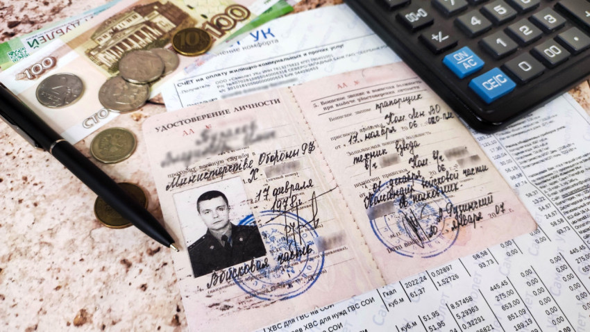 Счет за коммунальные услуги, деньги, ручка, калькулятор и удостоверение личности военного