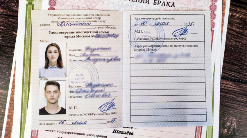 Удостоверение о многодетной семье на фоне документов