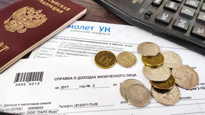 Квитанция за жилищно-коммунальные услуги, справка о доходах и паспорт на столе