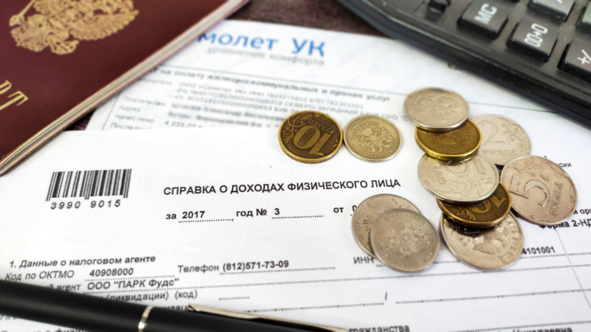 Квитанция за коммунальные услуги с паспортом, ручкой, монетами и калькулятором на столе