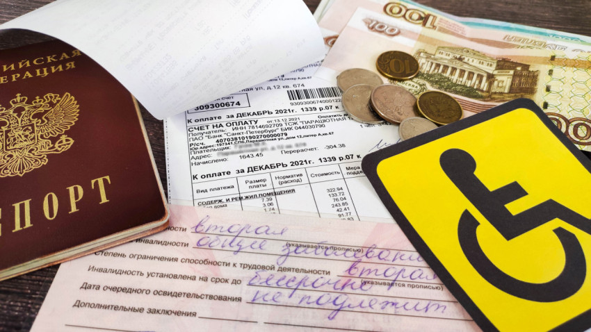 Квитанция за услуги ЖКХ, паспорт, деньги и удостоверении об инвалидности на столе