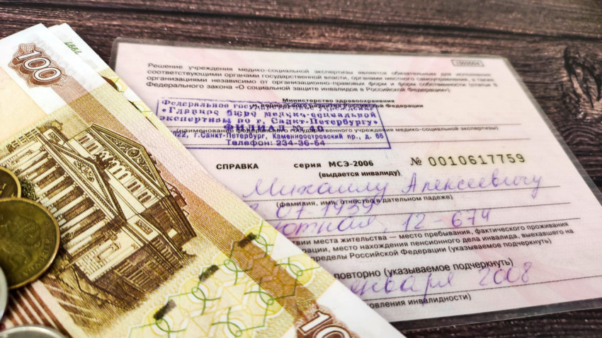 Удостоверение инвалида и денежные купюры