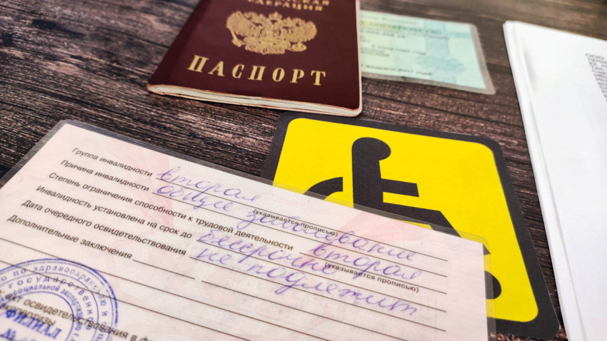 Справка инвалида на фоне документов и паспорта