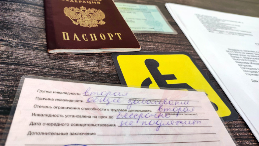 Удостоверение инвалида на фоне документов