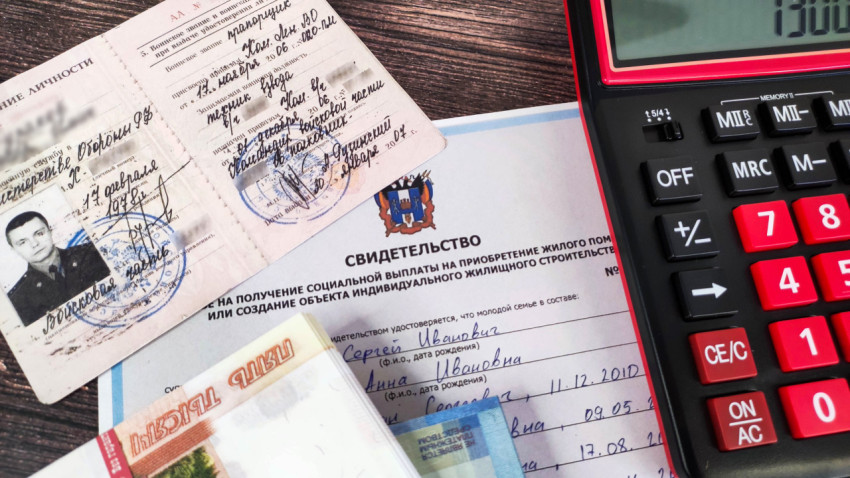 Удостоверение личности военнослужащего, жилищный сертификат, деньги и калькулятор на столе