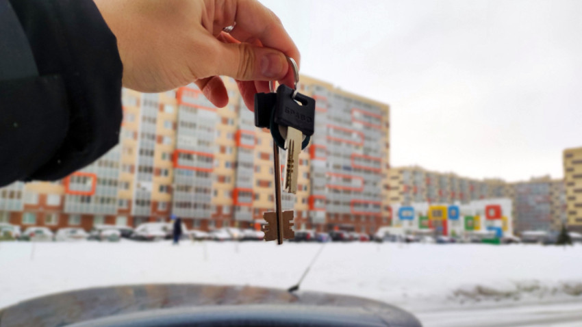 Ключи в руке на фоне новостройки