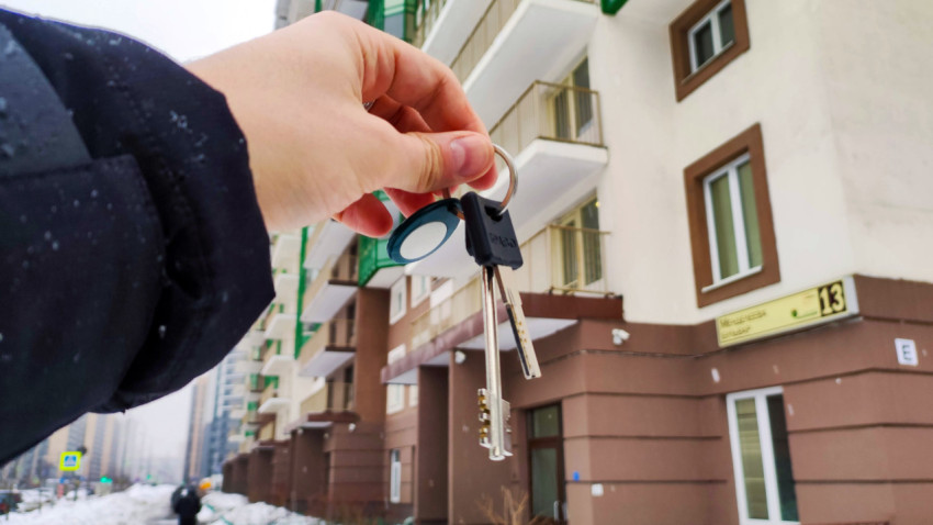 Ключи в руке на фоне нового дома