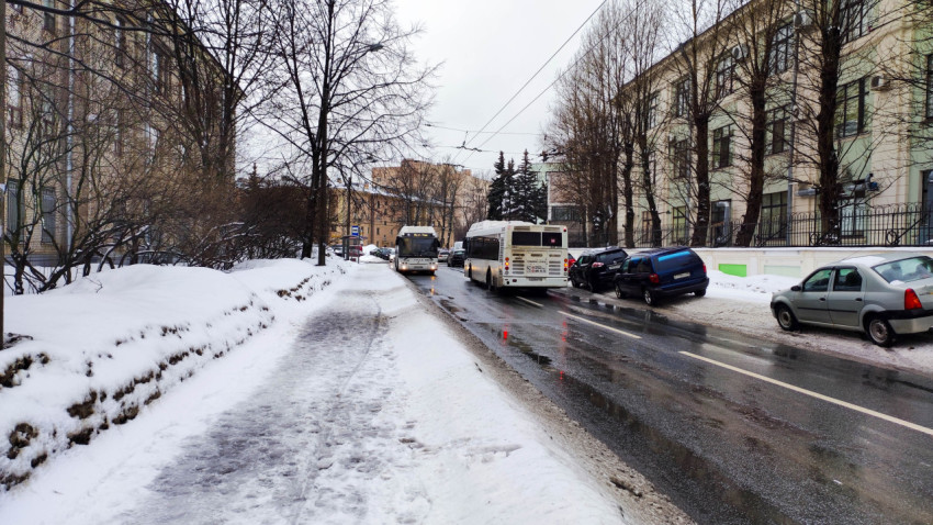 Заснеженная улица Курчатова с припаркованными автомобилями и автобусами