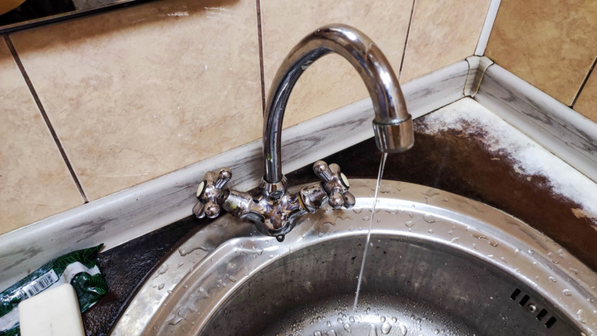 Течь воды из открытого крана в раковине на кухне