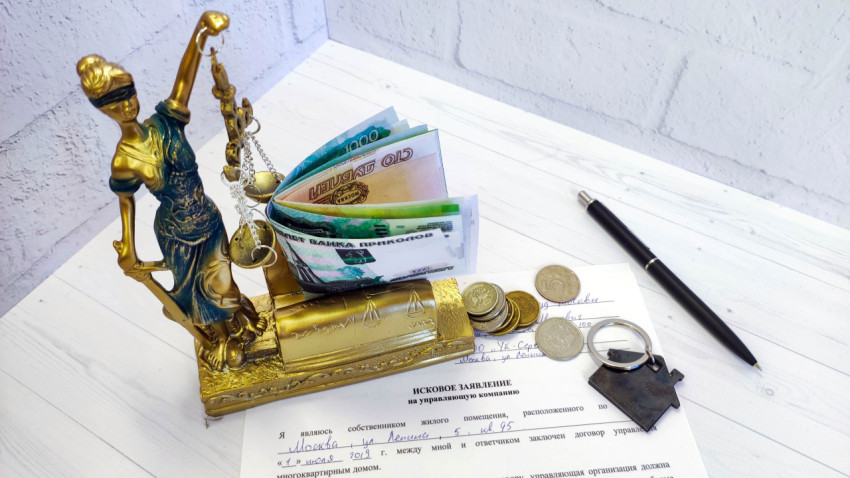 Заявление в суд против управляющей компании ЖКХ с фигуркой Фемиды и деньгами на столе