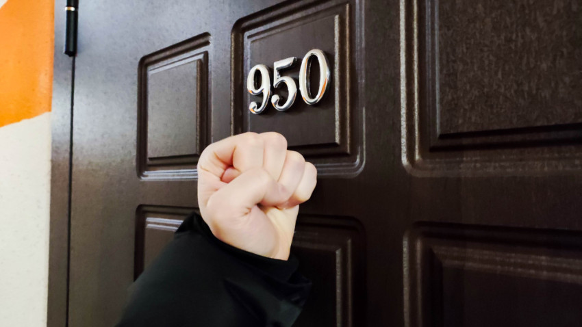 Мужчина стучит в дверь квартиры 950 в жилом комплексе