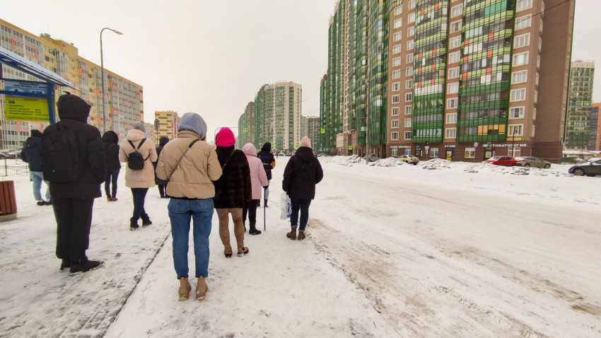 Люди ждут автобус на остановке в зимний день